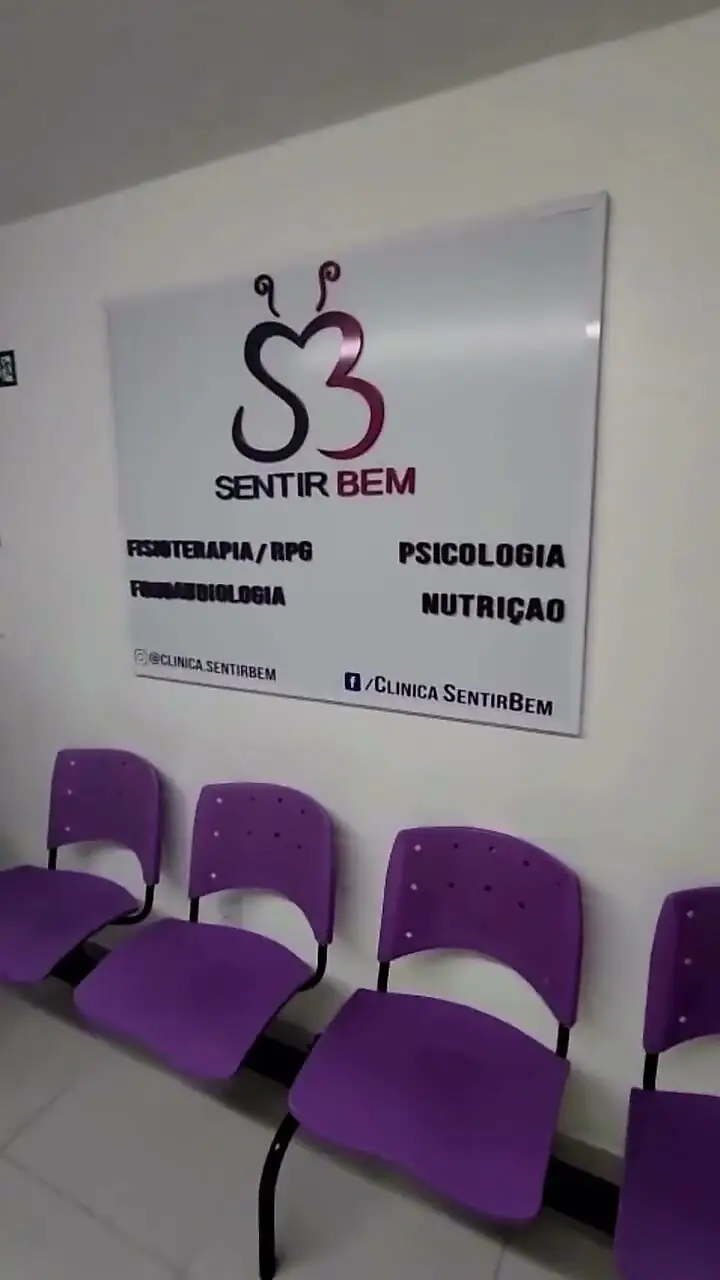 Recepção da Clínica Sentir Bem, com cadeiras roxas e a logomarca na parede