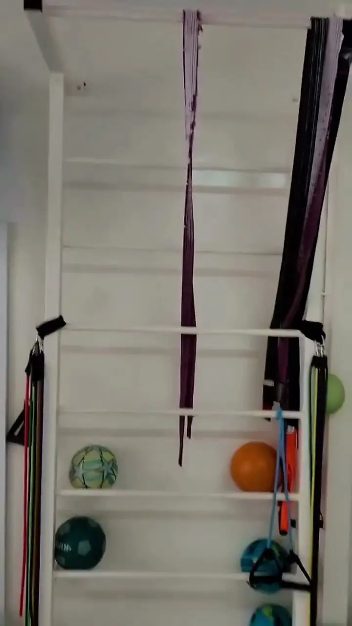 Sala de fisioterapia com espaldar, faixas elásticas e bolas de exercício