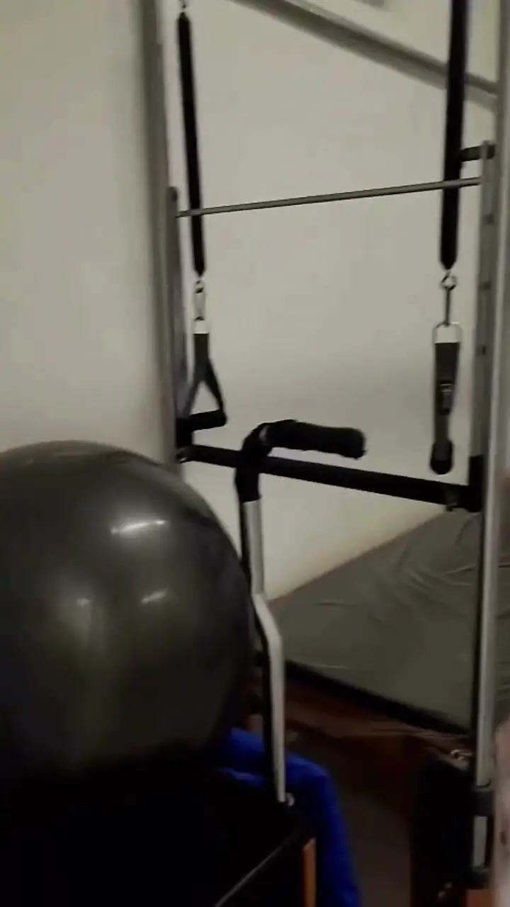 Aparelho de fisioterapia com barras, molas e bola de exercício