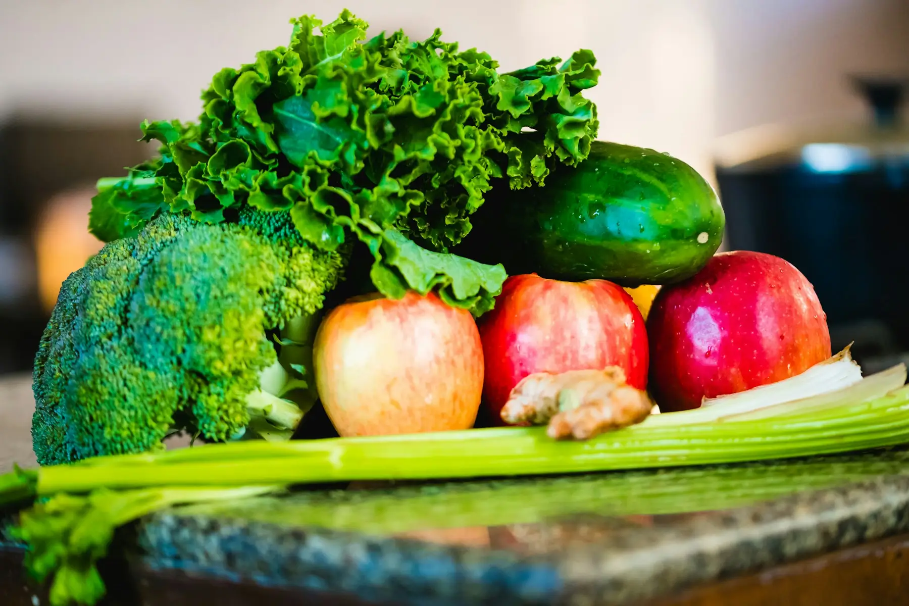 Brócolis, maçãs, pepino e folhas verdes frescas sobre a mesa